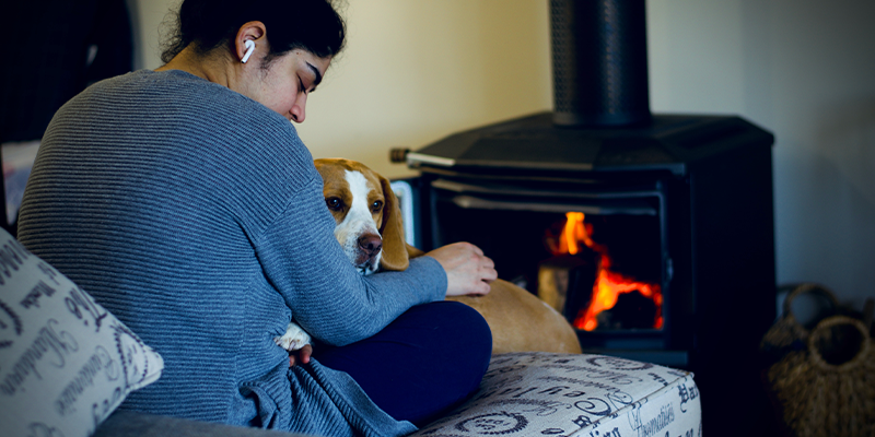 Women sitting with dog near fireplace